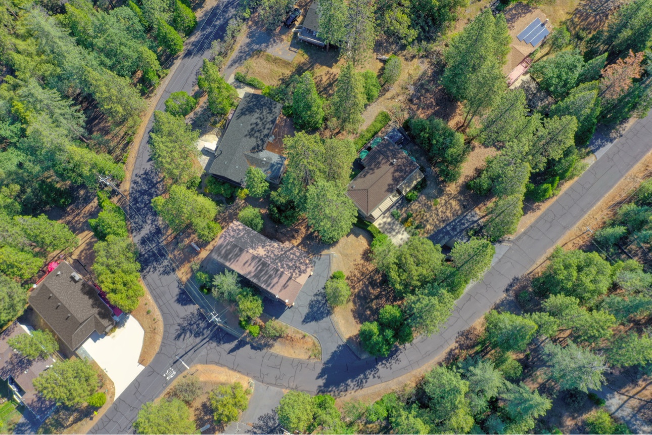 Aerial view of the cabin’s peaceful, tree-lined neighborhood